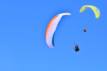 Paragliding. Paragliders on a blue sky background. Copy space.