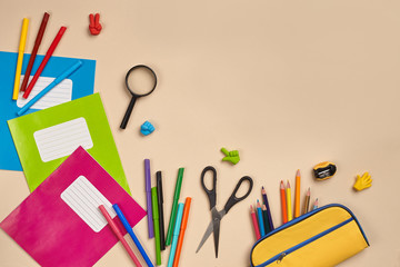 Fototapeta premium Flat lay photo of workspace desk with school accessories or office supplies on pink background.