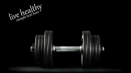 Black background with dark desk and dumbbells 