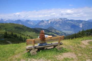 A woman is watching from the Wiedersbergerhorn mountain to the Alpbach valley, Tyrol - Austria