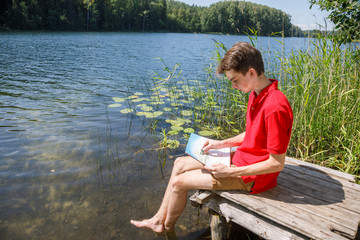 Teen boy sketching summer landscape with pastel sticks