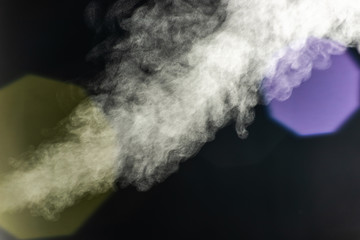 Bright steam on a dark background with yellow and purple bokeh