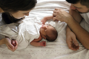  Father and mother with a newborn son. New young multi-generation family. Breast-feeding