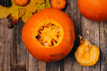 Opened Halloween pumpkin to clear it from seeds for carving to celebrate wooden table Trick or...
