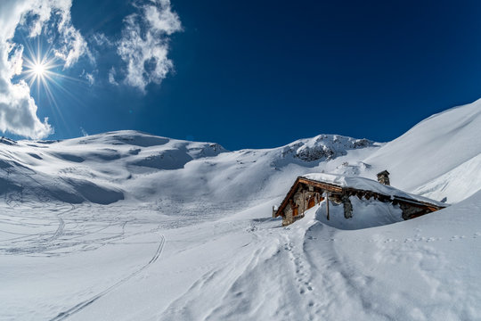 winter chalet in the mountains sun, snow in the Alps