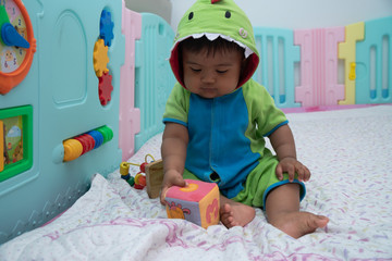 Cute little asian baby boy sitting play toy in room