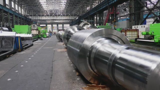 Rolls of steel lie on floor in production workshop of plant. Manufacture of steel products. Rolling forming rolls metal works. Rolling mill preparation workshop. Machining of machine parts
