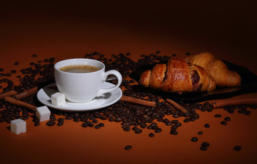 Coffee still life with croissants and cinnamon