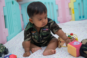 Cute little asian baby in Military uniform play toy
