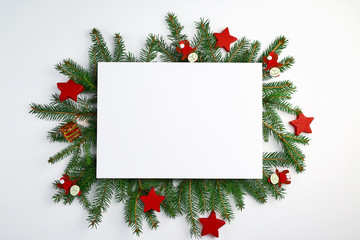 Fototapeta na wymiar congratulatory Christmas background with an empty white sheet and green branches of spruce