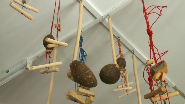 Handheld, low angle, medium close up shot of ladles and wooden tools hanging from the ceiling.