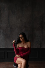 Obraz premium Young sexy brunette in a red dress