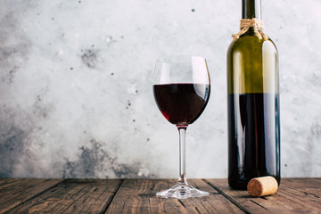 Red wine, glass and bottle on a stucco wall