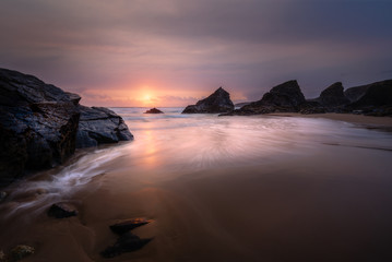 Sunset at the beautiful Bedruthan Steps in North Cornwall, with Silhouetted Sea Stacks, and Surf...