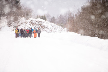 group of young people walking through beautiful winter landscape