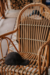 Cap with visor lies on wicker chair on veranda