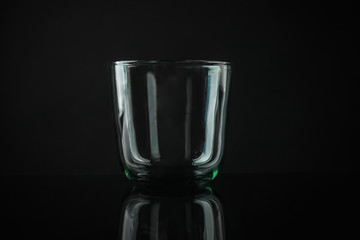Elegant empty colorful whiskey glass on black background
