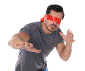 Young man wearing red blindfold on white background