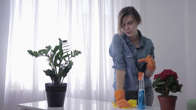 allergic to detergent, female tormented and sneezes covering his face with hands cleaning house because of household chemicals