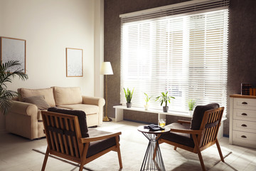 Living room interior with comfortable sofa and armchairs