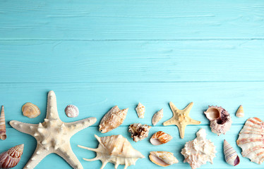 Flat lay composition with beautiful starfishes and sea shells on blue wooden table, space for text