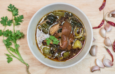 Pork brown pork leg in large plate with green pickled vegetables as side dishes in Thai restaurants