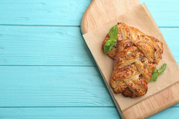 Fresh delicious puff pastry on light blue wooden table, top view. Space for text