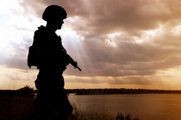 Soldier with machine gun patrolling outdoors. Military service