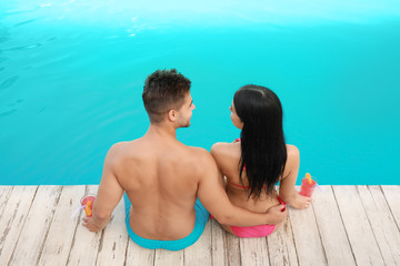 Fototapeta premium Woman in bikini with boyfriend near outdoor pool. Young couple