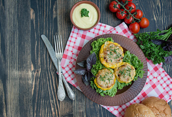 Baked Patty Pan Squash stuffed with meat and cheese, greens. Wood background.