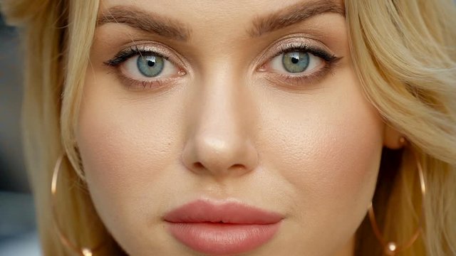Portrait of a blonde with full lips and blue eyes on a background of parking