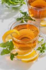 Black tea with mint and lemon on a white table