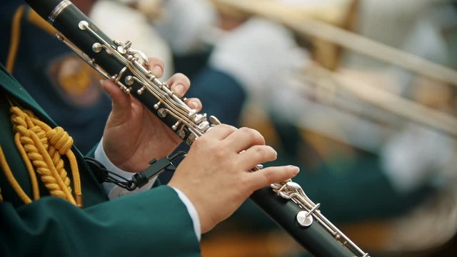 A wind instrument parade - a man in green costume playing clarinet at the military music festival