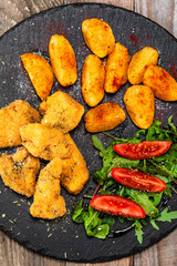Fried chicken nuggets, baked potatoes and vegetable salad
