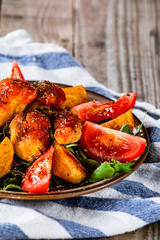 Fried chicken nuggets, baked potatoes and vegetable salad
