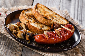 Grilled sausage, toasts and mushrooms