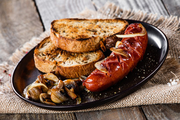 Grilled sausage, toasts and mushrooms
