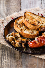 Grilled sausage, toasts and mushrooms