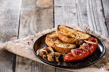 Grilled sausage, toasts and mushrooms