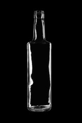 Open empty glass bottle isolated on black background. Clear glass
