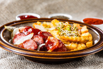 Grilled sausages, French fries and vegetables
