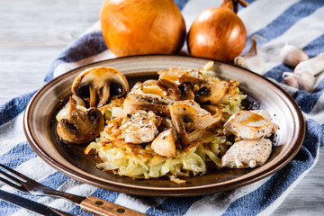 Potato cakes with chopped pork, gravy sauce and champignon