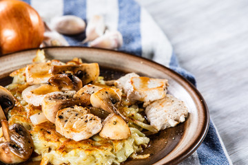 Potato cakes with chopped pork, gravy sauce and champignon