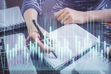 Financial chart drawn over hands taking notes background. Concept of research. Double exposure