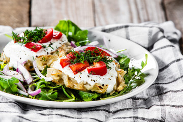 Potato cakes with sour cream and vegetables