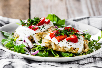 Potato cakes with sour cream and vegetables