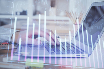 Double exposure of stock market graph with man working on laptop on background. Concept of financial analysis.