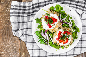 Potato cakes with sour cream and vegetables