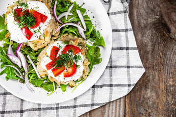 Potato cakes with sour cream and vegetables