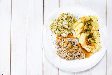 Fried pork chop, mashed potatoes and cabbageon